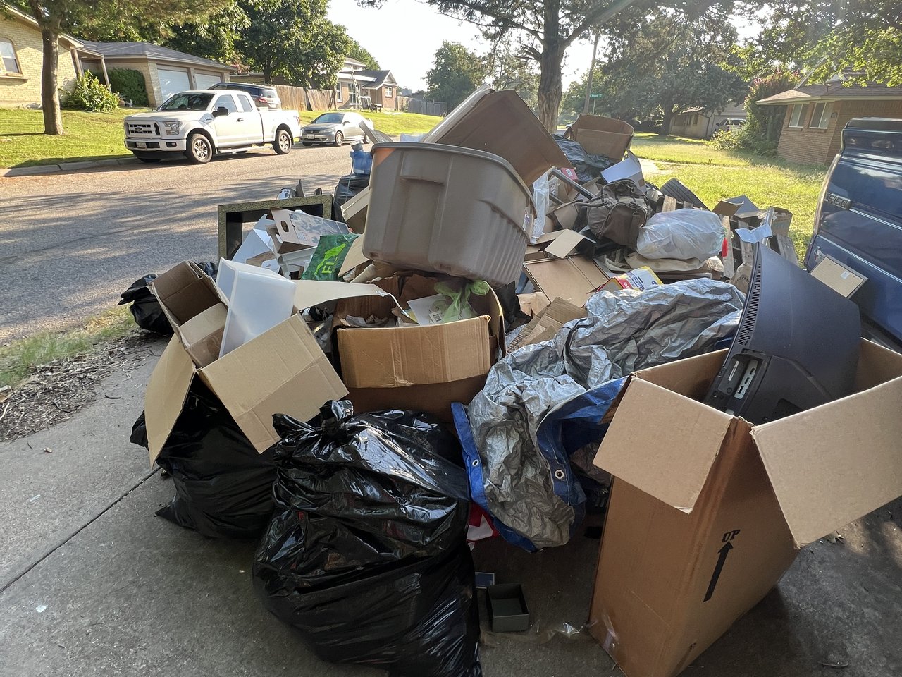 Texas Junk Boyz crew loading a mixed load of household junk into a 16 yard dump trailer